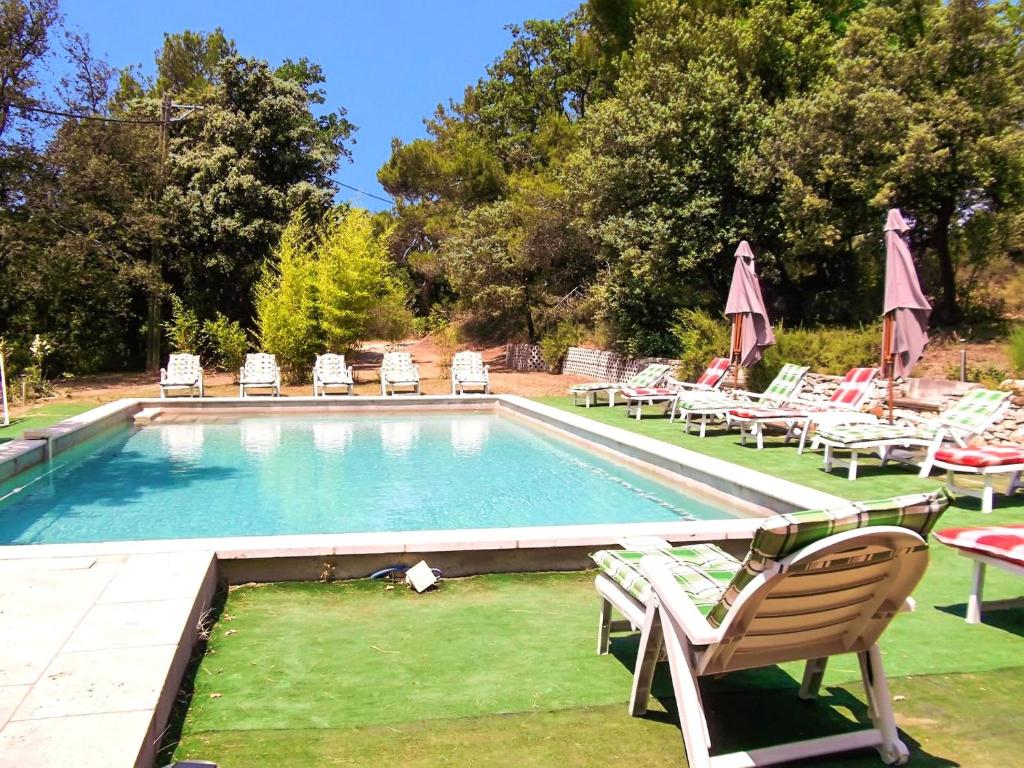 ヴェゾン・ラ・ロメーヌにあるVilla de 6 chambres avec piscine privee et jardin clos a Vaison la Romaineのスイミングプール(芝生の椅子、テーブル、椅子付)