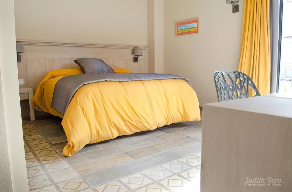 a bedroom with a bed with a yellow blanket at Hostal 1888 in Gironella