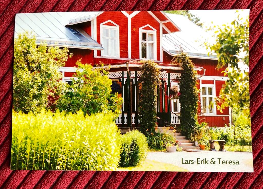 a red house with a black gate in a yard at 2-Bed Apartment overlooking the river in Avesta