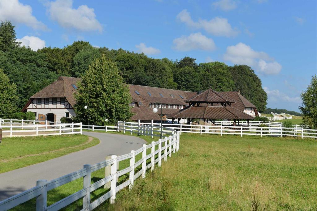 a farm with a white fence and some buildings at STöRTEBEKER APPARTEMENTS - "STöRTEBEKER PFERDEHOF" in Ralswiek