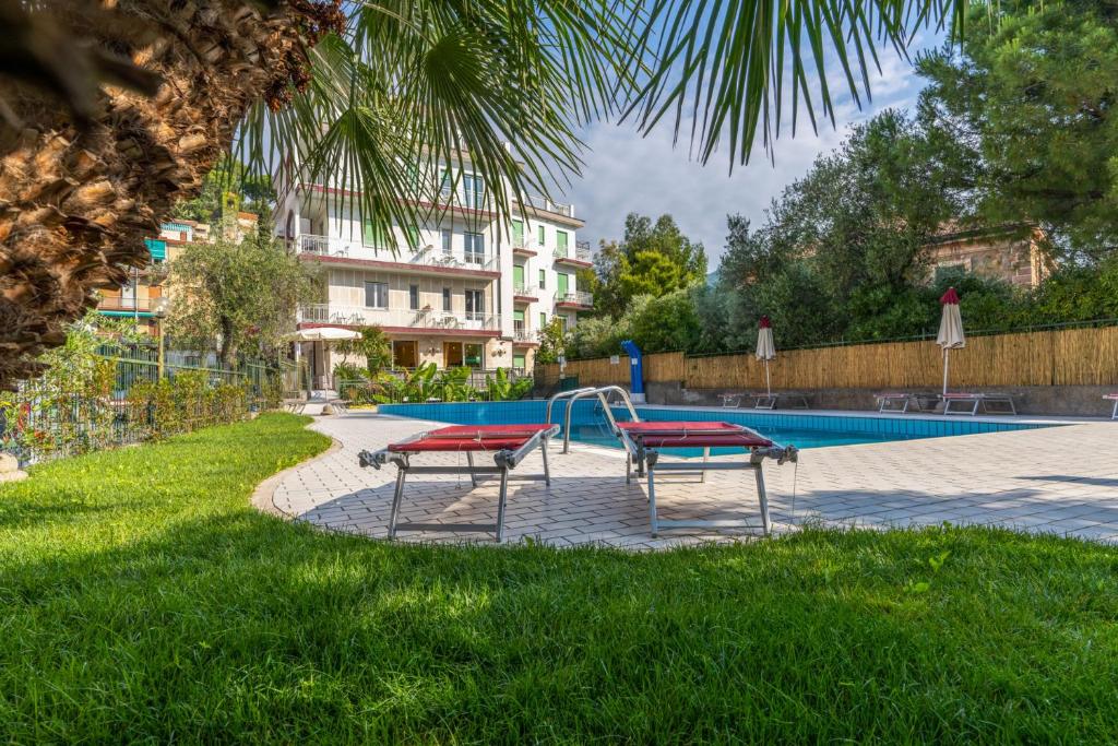 - une piscine avec deux bancs et une aire de jeux dans l'établissement Hotel Garden, à Alassio