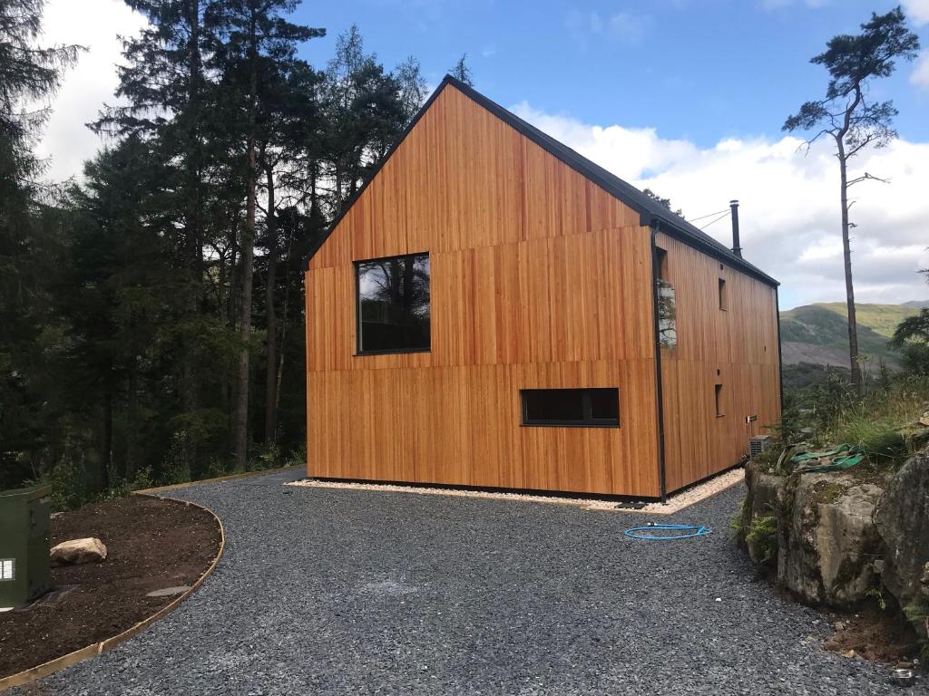 a wooden barn with a window on the side of it at An Caisteal chalet in Crianlarich