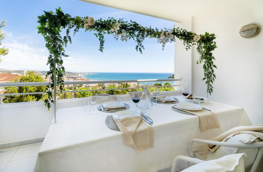 a table with wine glasses and a view of the ocean at Sea View Appartment Miraflores in La Cala de Mijas