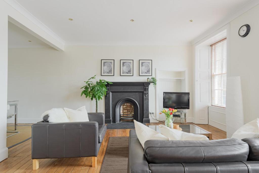 een woonkamer met 2 banken en een open haard bij The West Bow Apartment in Edinburgh