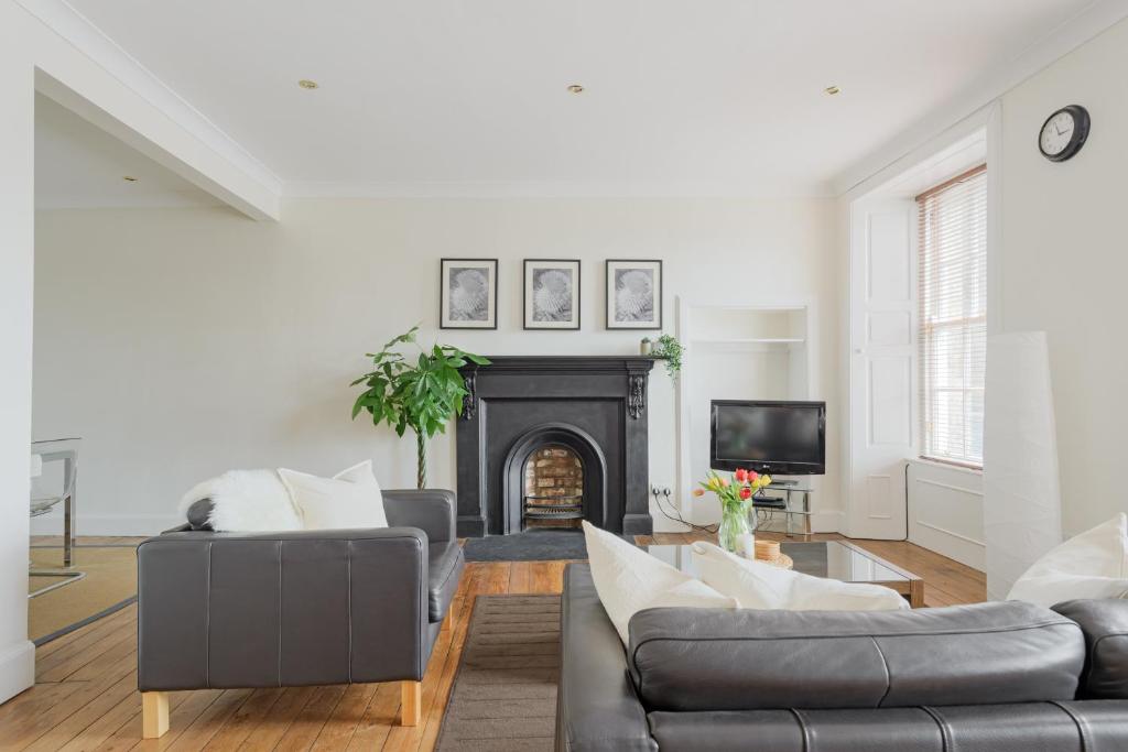 a living room with two couches and a fireplace at The West Bow Apartment in Edinburgh