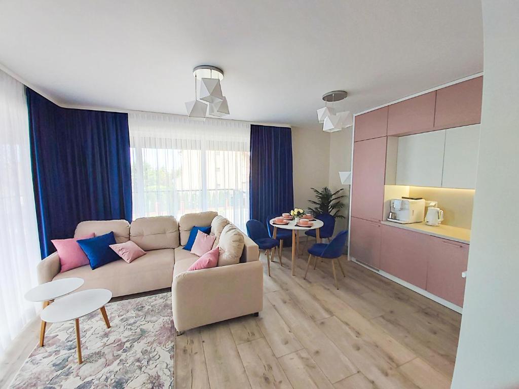 un soggiorno con divano e tavolo di Apartament Bella Rosa z podziemnym parkingiem a Kielce