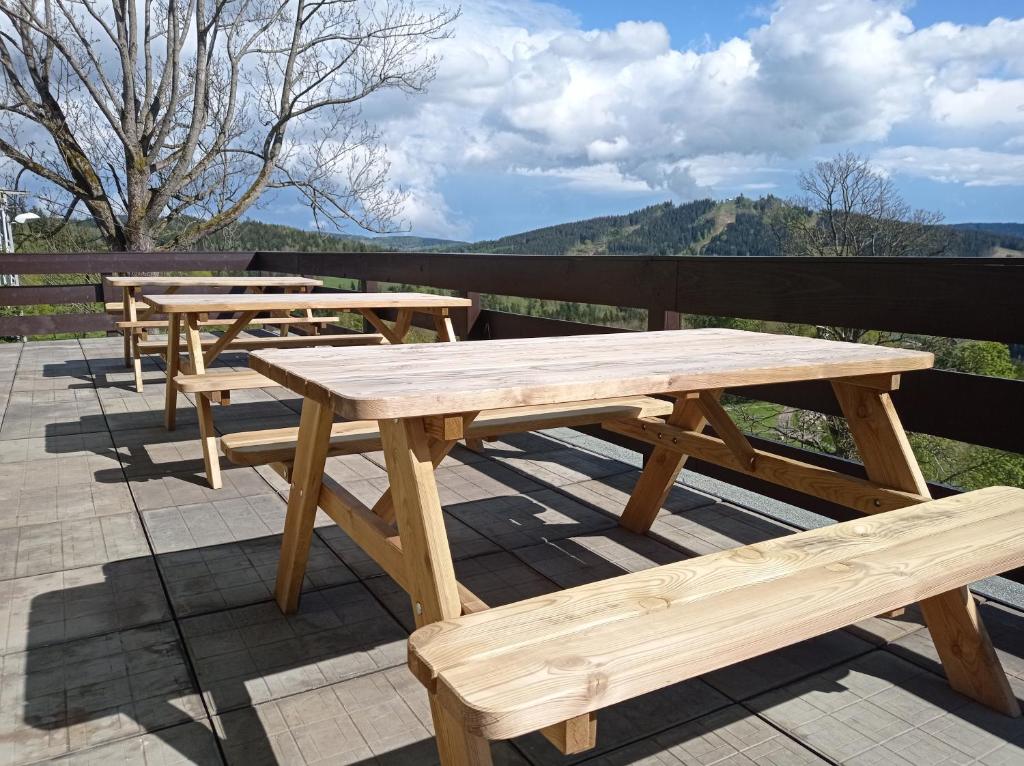 a row of wooden picnic tables on a roof at apartmány Kynast in Albrechtice v Jizerských horách