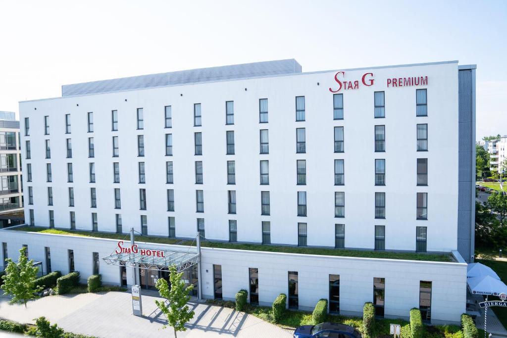 a white building with a sign on it at Star G Hotel Premium München Domagkstraße in Munich