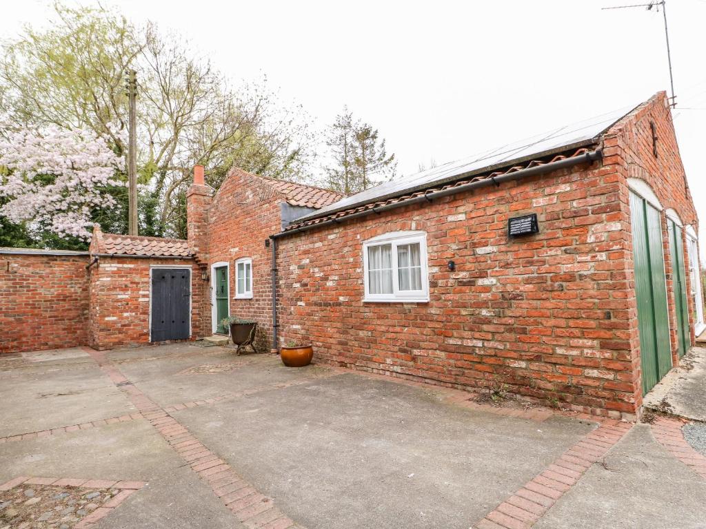 a brick building with a parking lot in front of it at The Old Farm Cottage in Louth