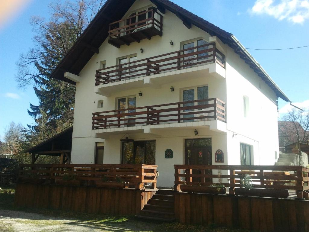 a large white house with a wooden fence at Casa Brândușa in Bran
