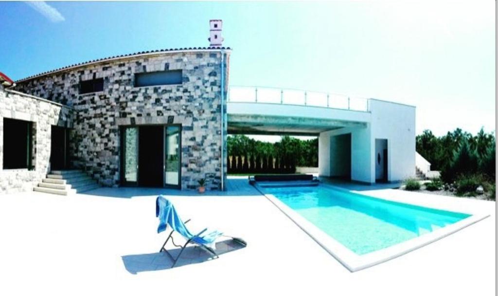 une maison avec une piscine à côté d'un bâtiment dans l'établissement Villa Lavanda in Kriz Sezana with private swimpool, à Sežana