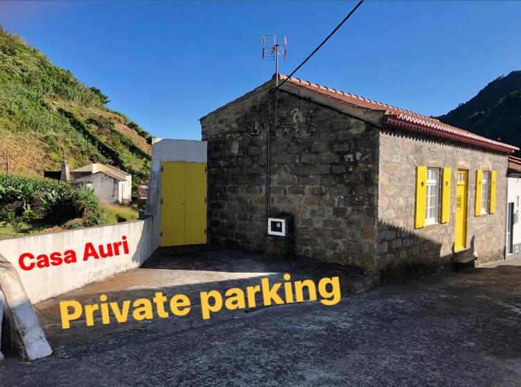 a small building with a yellow door and a sign at Casa Auri in Faial da Terra