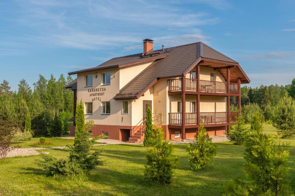 una casa grande en un campo de césped con árboles en Karumetsa Apartment, en Otepää