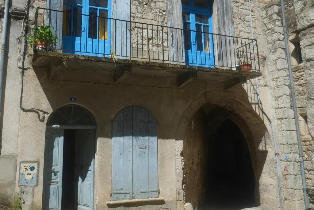 - un bâtiment avec un balcon, une porte bleue et une fenêtre dans l'établissement Large 3-Bed apartment in medieval quarter of Sauve, à Sauve