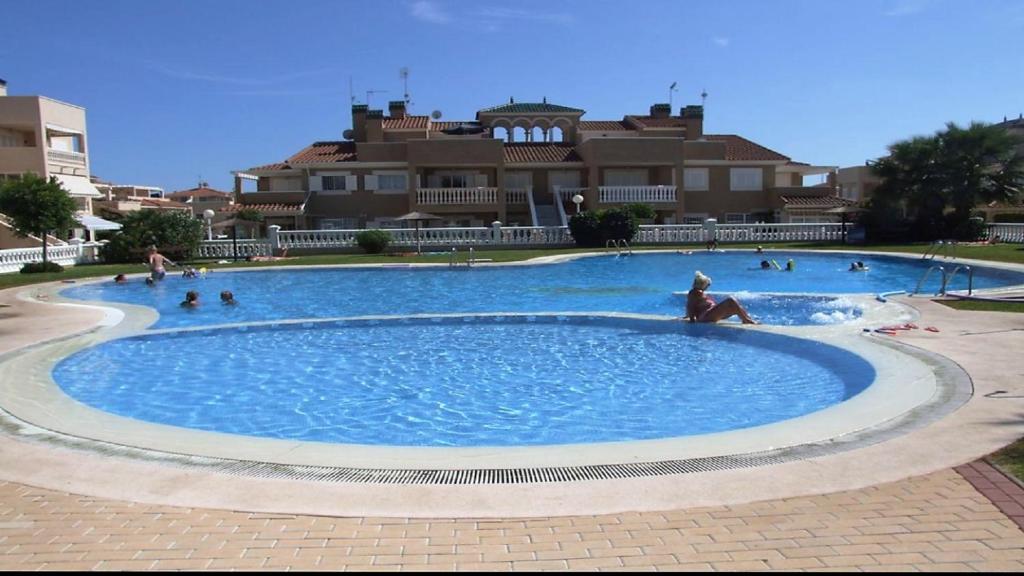 a large swimming pool with people in it at Inviting 2-Bed Apartment 5 minutes to the beach in Punta Prima