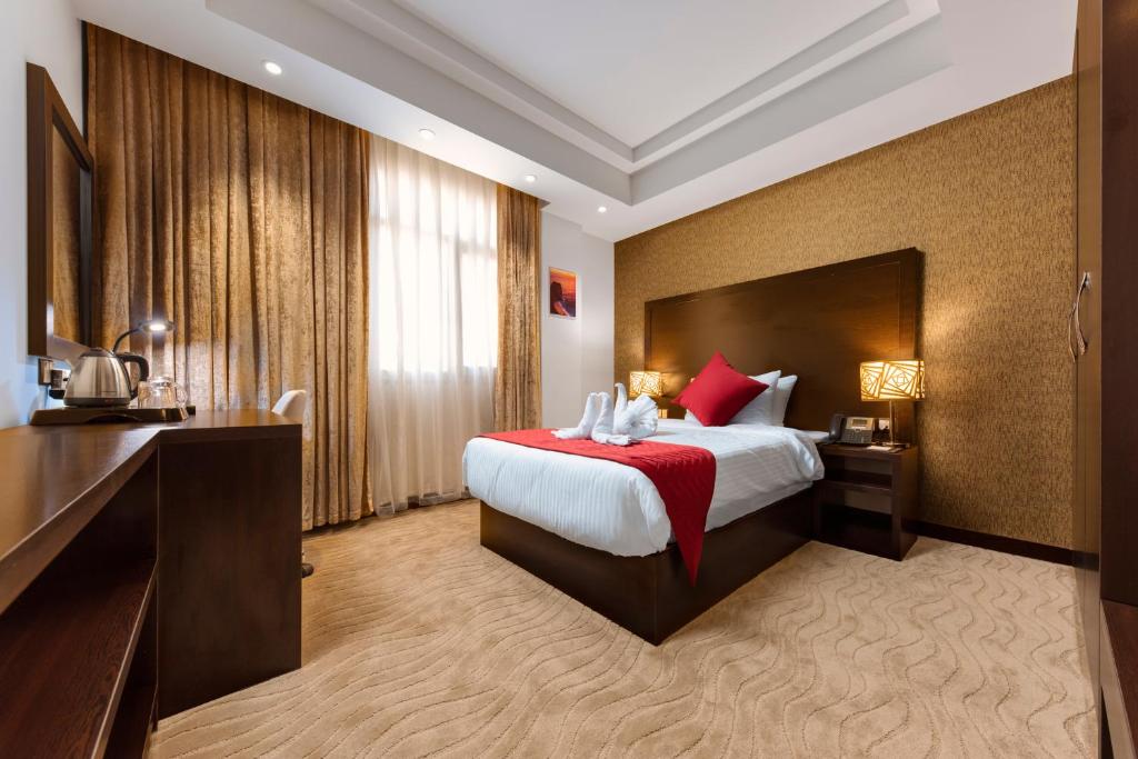 um quarto de hotel com uma cama grande com almofadas vermelhas em Horizon Hotel em Al Basrah