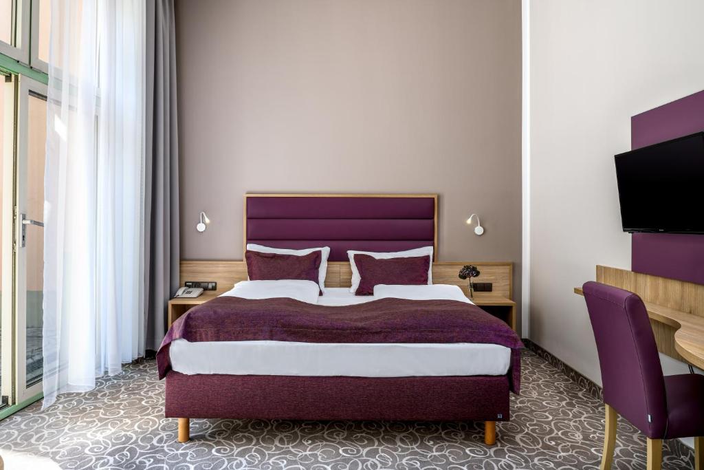 ウィーンにあるホテル シルトのベッドルーム(紫色のベッド1台、テレビ付)