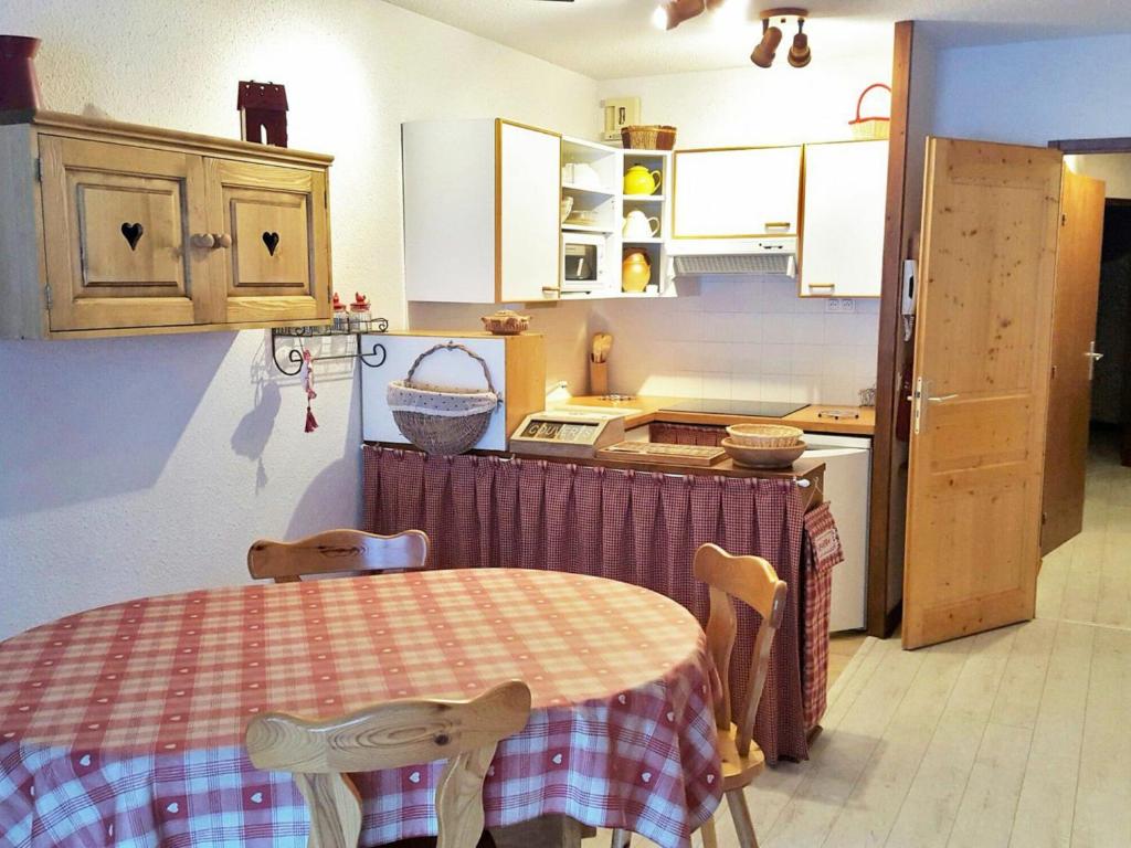 a kitchen with a table and chairs in a room at Appartement La Tania, 3 pièces, 7 personnes - FR-1-513-38 in La Tania