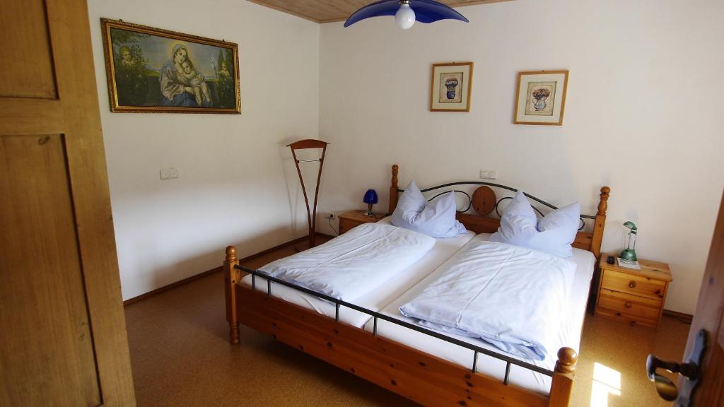 a bedroom with a bed with white sheets at Ferienwohnung Schultheiss in Plankenfels