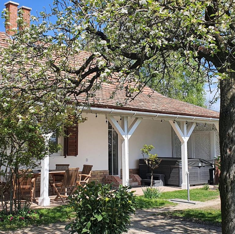 a white pavilion with chairs and a table at Héthatár Wellness Vendégház - Fecskefészek in Pusztavacs