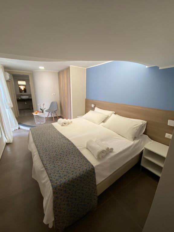 ein Schlafzimmer mit einem großen Bett mit weißer Bettwäsche und Kissen in der Unterkunft Coreammare in Neapel
