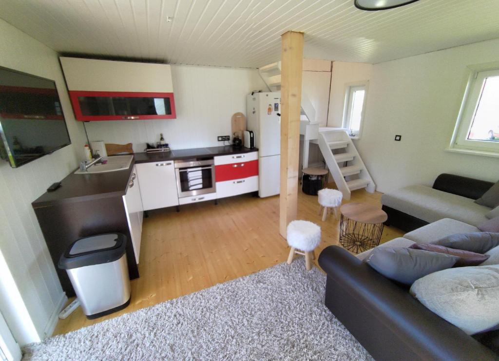 ein Wohnzimmer mit einem Sofa und einer Küche in der Unterkunft Prangli Valgekivi in Kelnase