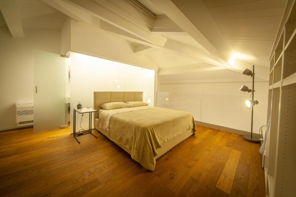 um quarto com uma cama grande e piso em madeira em Mori Siciliani House em Aci Castello
