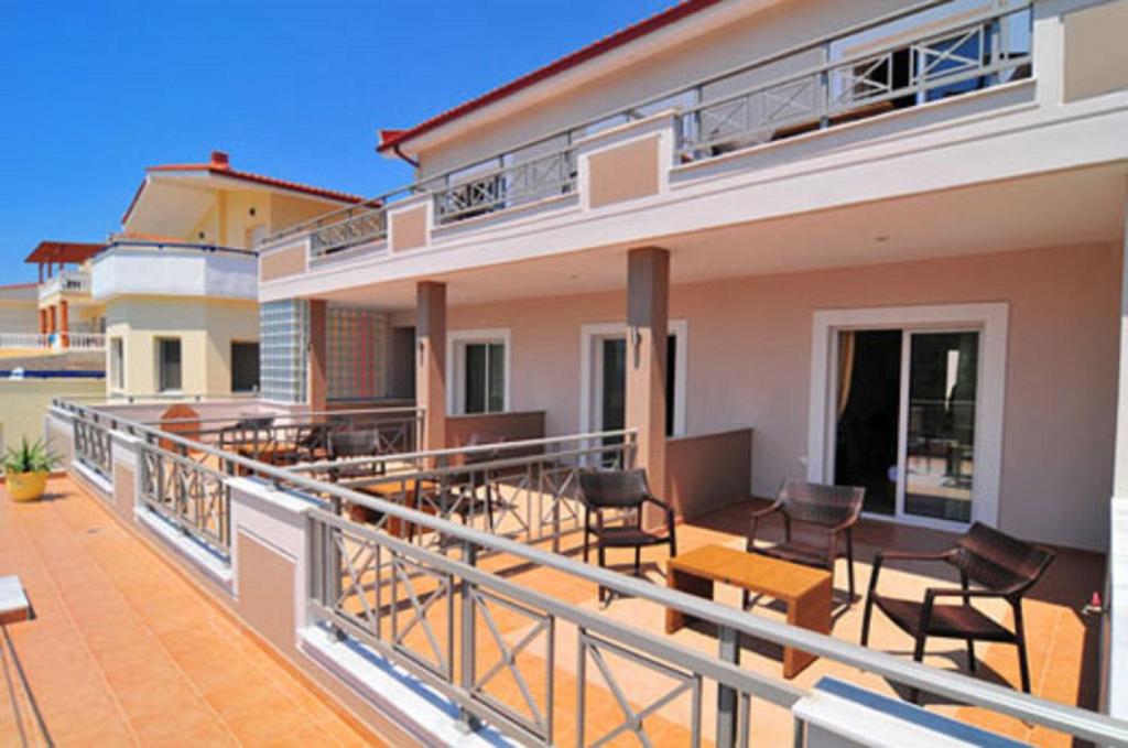 a balcony of a house with chairs and tables at Thalassorama Studios in Skala Marion