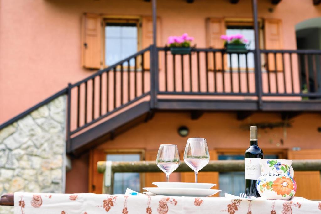 a table with two wine glasses and a bottle of wine at Casa Maso Clamer in Andalo