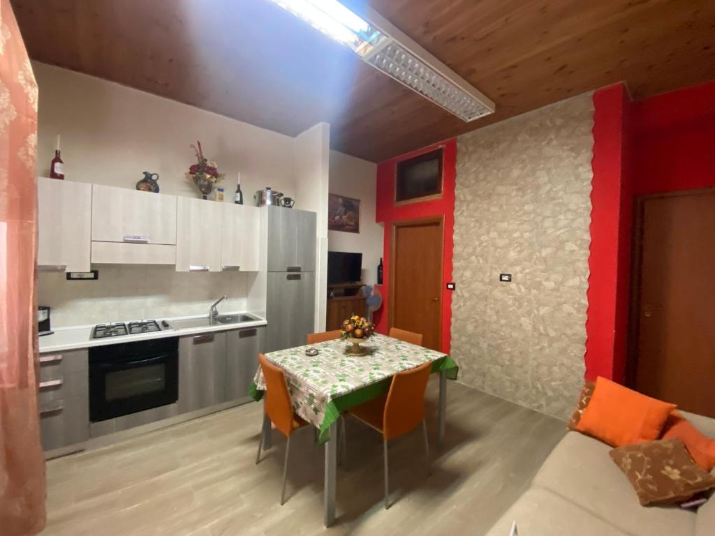 eine Küche und ein Esszimmer mit einem Tisch und Stühlen in der Unterkunft La casa di nonna rosetta in Cirò Marina