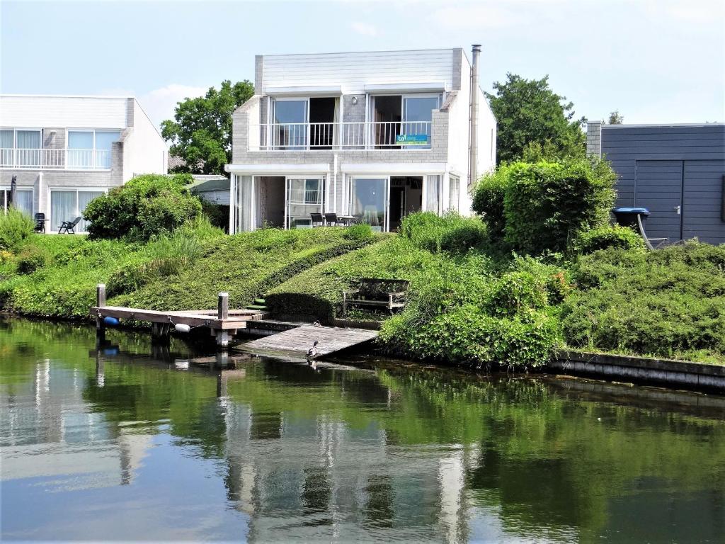 a house on the bank of a river at Vakantiewoning direct aan het Veerse Meer in Kortgene