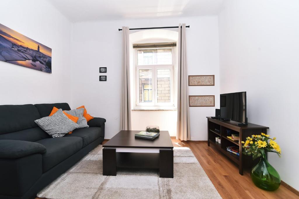a living room with a couch and a coffee table at Apartment Stross Rijeka in Rijeka