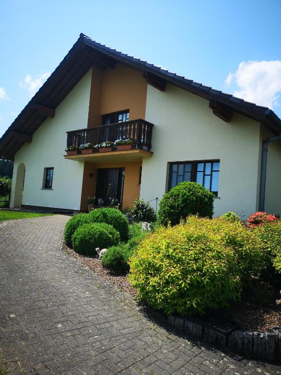 a white house with a balcony and some bushes at Martina in Saint-Vith