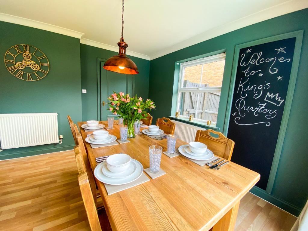 a dining room with a wooden table and green walls at Kings Quarters Boutique Rooms in Hartford