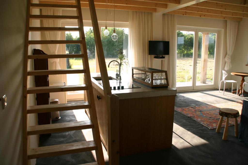 Habitación con una escalera que conduce a una sala de estar. en Huisje Wevers en Bathmen