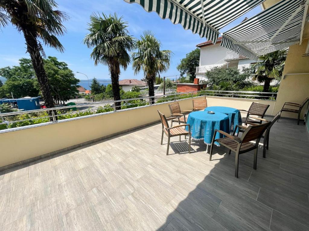 a patio with a blue table and chairs on a balcony at Apartmani Talia Crikvenica in Crikvenica