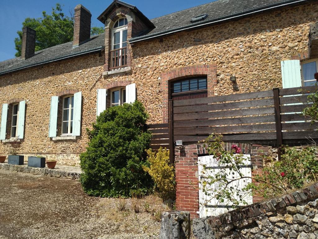 ein Backsteinhaus mit einer Bank davor in der Unterkunft La Ferme de Spoir in Mignières