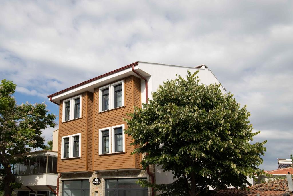 a wooden house with a tree in front of it at Elia İmroz Hotel in Gokceada Town