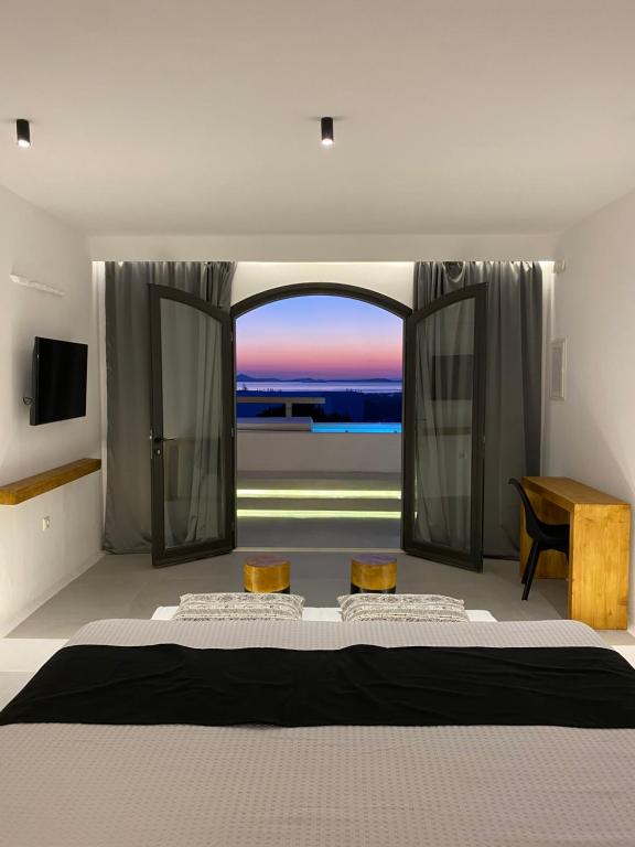 a bedroom with a large bed and a large window at Villa Agrabely & Suites in Galanado