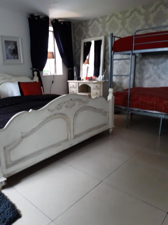 a bedroom with a white bed and a red bedspread at The White Dove Bed and Breakfast with Glamping Newark showground in Newark-on-Trent