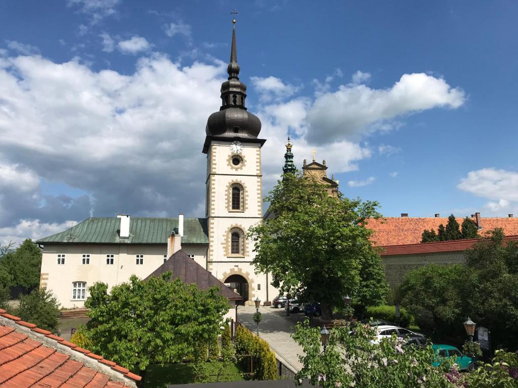 a large white building with a clock tower at Noclegi U Bram Klasztoru in Stary Sącz