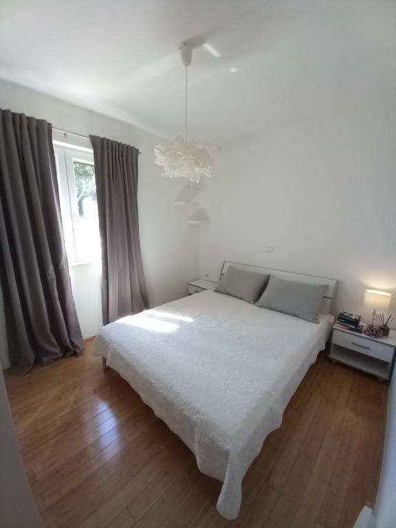 a bedroom with a white bed and a window at House Pierro in Orasac