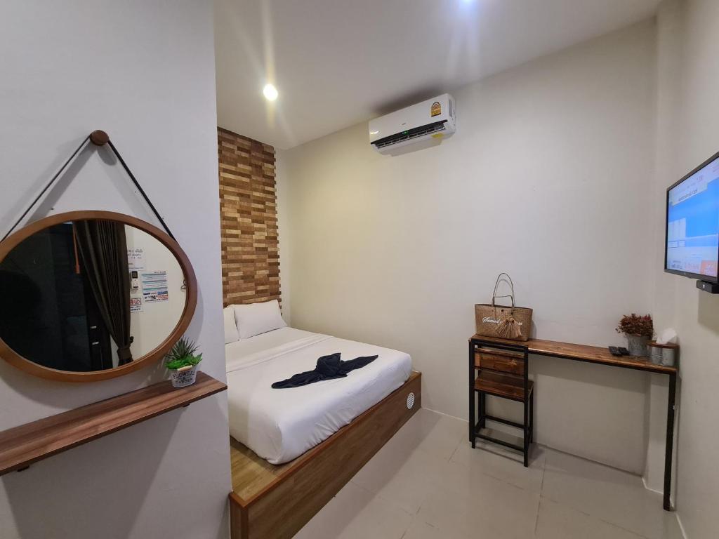 a small room with a bed and a mirror at Samed Your House in Ko Samed