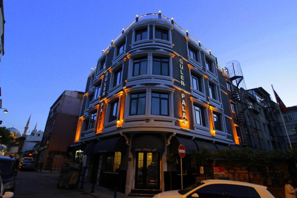 Güler Palas Hotel في إسطنبول: مبنى أزرق عليه أضواء برتقالية