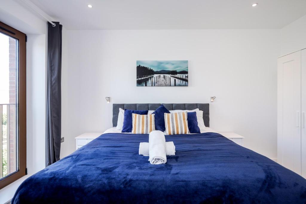 a bedroom with a blue bed with a towel on it at Deluxe 1 Bedroom St Albans Apartment - Free Wifi in St. Albans