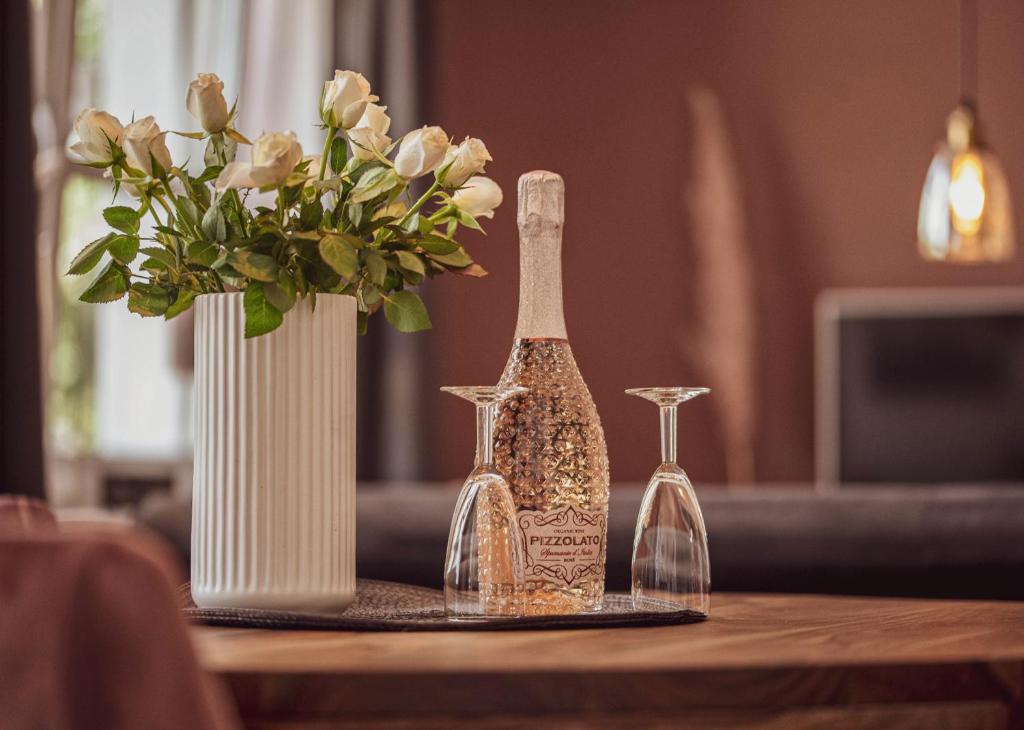 une table avec trois bouteilles et un vase avec des fleurs dans l'établissement City Loft, à Eisenach