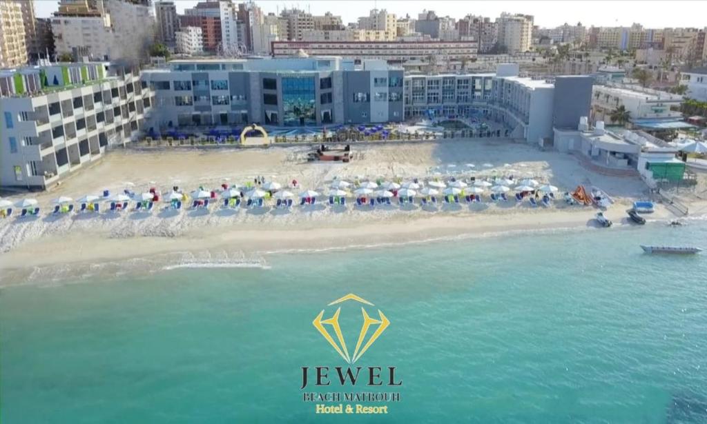 una playa con un montón de sombrillas en el agua en Jewel Beach Matrouh Hotel en Marsa Matruh