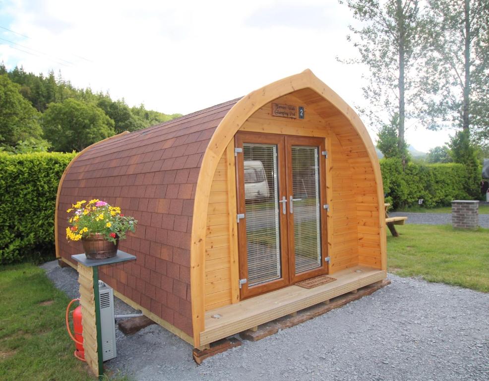 un edificio de madera con una ventana en un patio en Glamping Huts in Heart of Snowdonia en Dolgellau