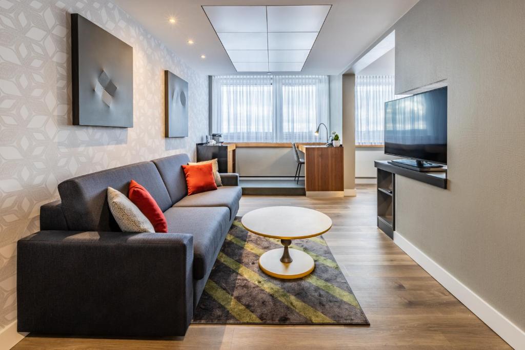 a living room filled with furniture and a tv at Radisson Blu Hotel Erfurt in Erfurt