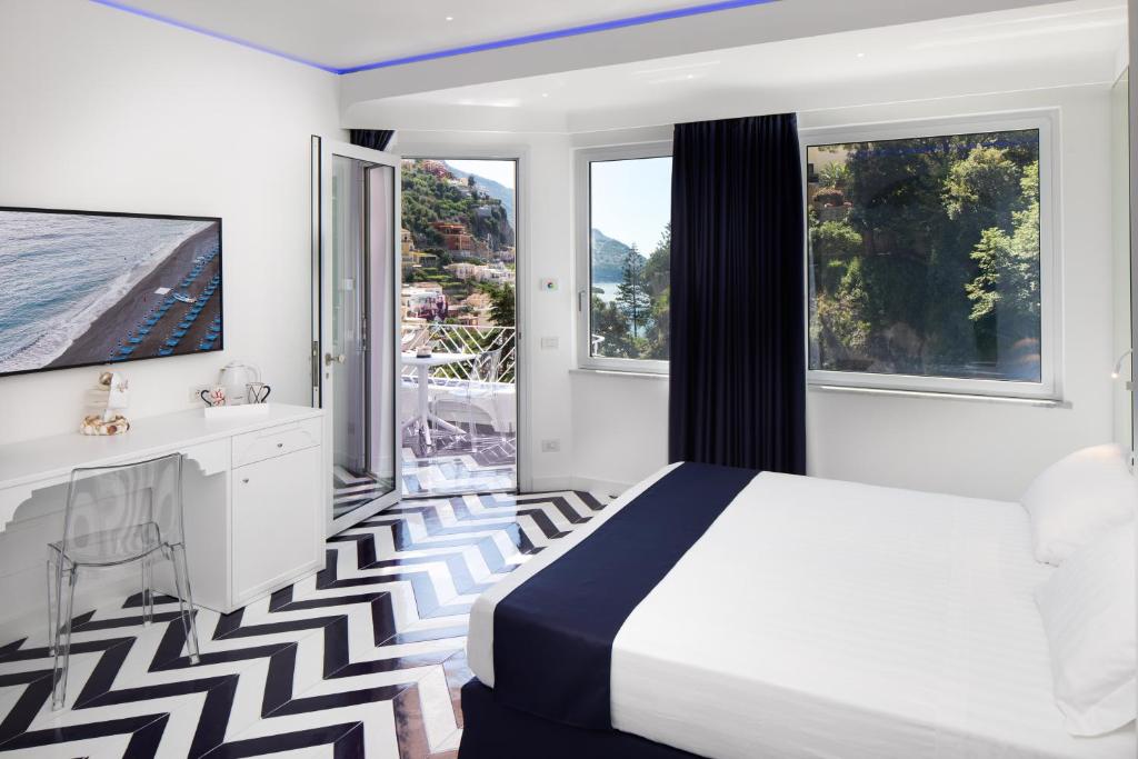 a bedroom with a bed and a large window at Positamy in Positano